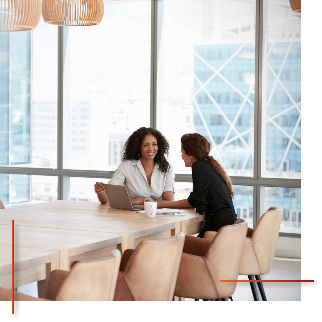 Two business women sitting at a desk in a modern office